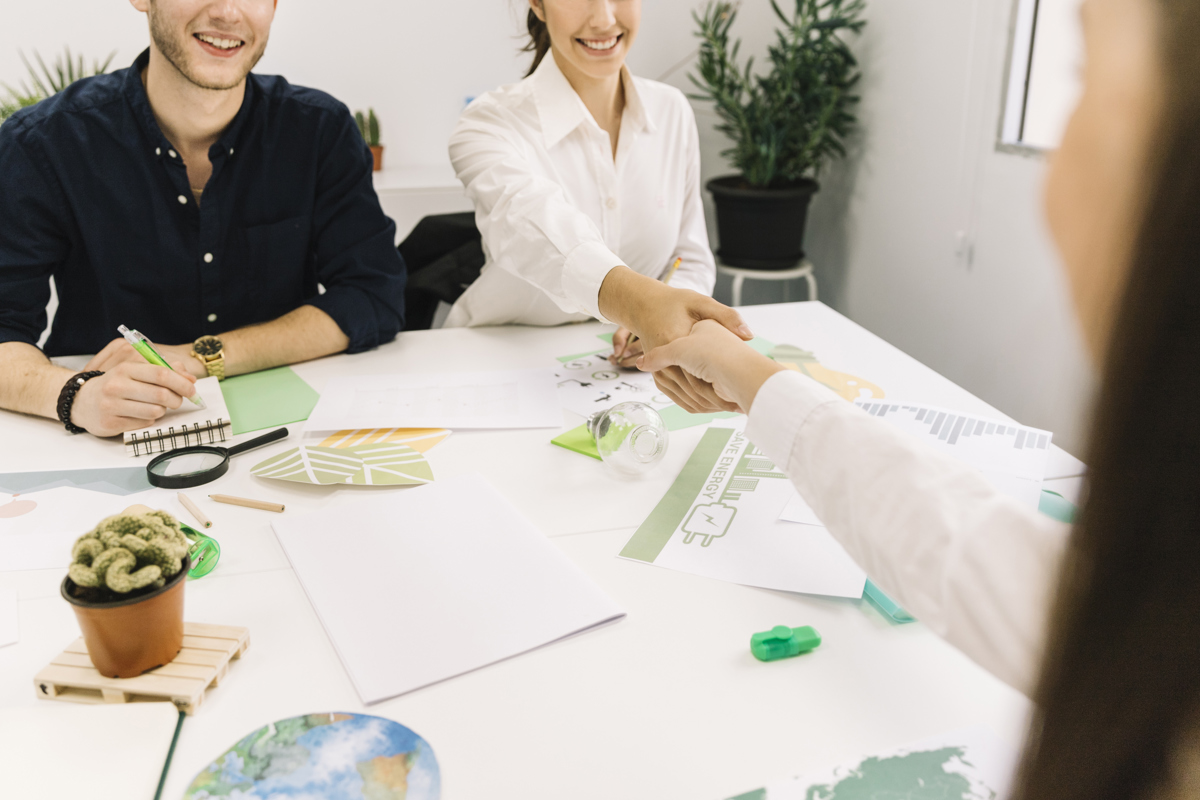two-businesswoman-shaking-hands-desk-office.jpg